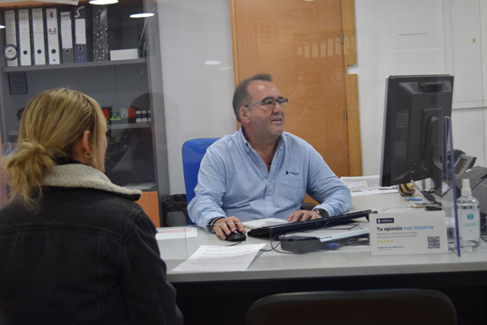 A technician assists a person in a Hidralia office.